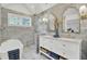 Elegant bathroom featuring double vanity, marble tile, soaking tub, and glass enclosed shower at 126 Sparrow Dr, Isle of Palms, SC 29451