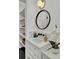 Stylish bathroom vanity with a round mirror, white marble countertop, and open shelving for storage at 126 Sparrow Dr, Isle of Palms, SC 29451