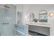 Bright bathroom with blue tiled shower, double sink vanity and marble countertops at 126 Sparrow Dr, Isle of Palms, SC 29451