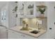 Close-up of a charming butler's pantry featuring a decorative backsplash, stylish faucet and decor at 126 Sparrow Dr, Isle of Palms, SC 29451