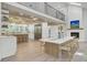 Bright dining room features modern light fixtures and a table for eight, adjacent to the kitchen and a cozy fireplace at 126 Sparrow Dr, Isle of Palms, SC 29451