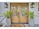 Elegant double front doors flanked by potted plants and stylish lanterns, creating an inviting entrance at 126 Sparrow Dr, Isle of Palms, SC 29451