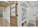 Hallway with wooden-framed glass door, shelving, shiplap walls, and hardwood flooring at 126 Sparrow Dr, Isle of Palms, SC 29451
