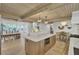 Bright, open kitchen featuring a large island, wooden ceiling, and dining area with ample natural light at 126 Sparrow Dr, Isle of Palms, SC 29451