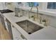 Elegant kitchen sink with white marble countertops, brass fixtures, and stainless steel appliances nearby at 126 Sparrow Dr, Isle of Palms, SC 29451