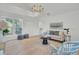 Bright living room featuring hardwood floors, light furniture, and a modern chandelier fixture at 126 Sparrow Dr, Isle of Palms, SC 29451
