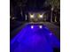 Inviting outdoor pool with ambient lighting and charming poolside seating area for relaxing evenings at 126 Sparrow Dr, Isle of Palms, SC 29451