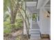 Inviting home with a white porch, grey floors, and stairs surrounded by lush landscaping at 126 Sparrow Dr, Isle of Palms, SC 29451