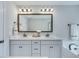 Well-lit bathroom with double vanity, large mirror, white cabinets, and modern fixtures at 1426 Tannery Row, Johns Island, SC 29455