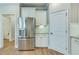 Elegant kitchen area with stainless steel refrigerator, white cabinets, tile backsplash and wood flooring at 1426 Tannery Row, Johns Island, SC 29455
