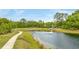 Scenic view of the community pond with a fountain, walking path, playground, landscaping, and trees at 1426 Tannery Row, Johns Island, SC 29455