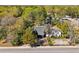 An aerial view shows a house with a dark roof and chimney surrounded by lots of greenery, next to another house at 1456 Remount Rd, North Charleston, SC 29406