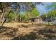 An unfurnished and fenced backyard area featuring a mature tree canopy overhead and a storage building at 1456 Remount Rd, North Charleston, SC 29406