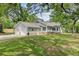 View of a well-kept home with a two-car garage, sun room and lush lawn at 146 Rivers Edge Way, Wando, SC 29492