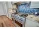 Stainless steel gas range with hood and mosaic tile backsplash complemented by granite countertops at 146 Rivers Edge Way, Wando, SC 29492