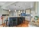 Kitchen with a large island, barstool seating, granite countertops, stainless steel range hood, and mosaic tile backsplash at 146 Rivers Edge Way, Wando, SC 29492