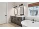 Bright bathroom with a double sink vanity, soaking tub, and a window with a view at 1604 Bernier Commons, Johns Island, SC 29455