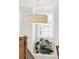 Bright bonus room with wicker light fixture, staircase, and large potted plant at 1604 Bernier Commons, Johns Island, SC 29455