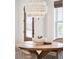 Chandelier illuminates a round wooden table, set with a decorative bowl, and wicker chairs at 1604 Bernier Commons, Johns Island, SC 29455