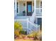 Inviting front porch with white railings, decorative sconces, plants, and a wood door with glass panels at 1604 Bernier Commons, Johns Island, SC 29455