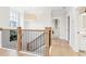 Upstairs hallway featuring wood floors, an eye-catching light fixture and a wooden railing with black spindles at 1604 Bernier Commons, Johns Island, SC 29455