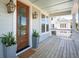 Welcoming front porch with wooden floors, an ornate front door, lantern lights and potted plants at 1604 Bernier Commons, Johns Island, SC 29455