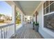 Inviting front porch with wooden floors, white columns, lantern lights and potted plants at 1604 Bernier Commons, Johns Island, SC 29455