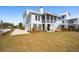 Stunning elevated coastal home featuring a screened porch and attached garage on a well-manicured lot at 1604 Bernier Commons, Johns Island, SC 29455