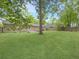 Large backyard showing a house with a deck, green lawn, mature trees, and a privacy fence at 166 Braly Dr, Summerville, SC 29485