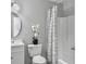Clean bathroom with white vanity, toilet, shower with curtain and a decorative flower arrangement on the toilet tank at 166 Braly Dr, Summerville, SC 29485