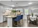 Bright kitchen with white cabinets, stainless steel appliances, an island with bar seating, and a dining table at 166 Braly Dr, Summerville, SC 29485