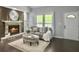 Comfortable living room featuring a brick fireplace, grey sofa, ottoman, and a white door, ideal for relaxation at 166 Braly Dr, Summerville, SC 29485
