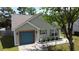Charming single-story home with a blue garage door, complemented by well-maintained landscaping at 203 Two Hitch Rd, Goose Creek, SC 29445