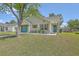 Charming single-story home features a vibrant teal door and garage, lush lawn, and mature shade tree at 203 Two Hitch Rd, Goose Creek, SC 29445