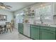 Well-lit kitchen boasts updated green cabinets, stainless steel appliances, and stylish backsplash with a sunlit dining nook at 203 Two Hitch Rd, Goose Creek, SC 29445