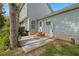 A side view of a house with light-blue siding and a brick patio, shaded by a large tree at 205 Lynton Ct, Goose Creek, SC 29445