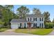 Charming two-story home with blue siding, black shutters, red door and a well-manicured front yard at 205 Lynton Ct, Goose Creek, SC 29445