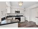 Modern kitchen featuring white cabinets, stainless steel appliances, sleek black countertops, and stylish lighting at 205 Lynton Ct, Goose Creek, SC 29445