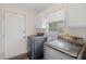 Bright laundry room featuring modern washer and dryer units and ample cabinet storage space at 205 Lynton Ct, Goose Creek, SC 29445