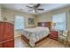 The warm bedroom features a bed, wooden furniture, and a ceiling fan, creating a cozy and inviting space at 2275 Pristine View Rd, Charleston, SC 29414