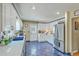 This bright kitchen features white cabinets, a stainless steel refrigerator, and complementary blue counters and tile floors at 2275 Pristine View Rd, Charleston, SC 29414