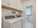 The laundry room includes side by side washer and dryer units with overhead storage and access to an adjacent lavatory at 2275 Pristine View Rd, Charleston, SC 29414