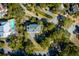 Aerial view of home nestled amongst mature trees, featuring an in-ground pool and winding driveway at 23 Fairway Village Ln, Isle of Palms, SC 29451