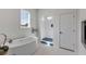 Modern bathroom featuring a sleek soaking tub and glass-enclosed shower with blue tiled base at 23 Fairway Village Ln, Isle of Palms, SC 29451
