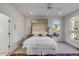 Bright bedroom features a luxurious bed with decorative pillows, ceiling fan, and a scenic window view at 23 Fairway Village Ln, Isle of Palms, SC 29451