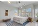 Bright bedroom with a large bed, multiple windows, and a stylish blue rug at 23 Fairway Village Ln, Isle of Palms, SC 29451