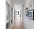 Bright hallway with light wood floors, white walls, and decorative framed art at 23 Fairway Village Ln, Isle of Palms, SC 29451