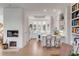 Well-lit kitchen featuring a fireplace, white cabinetry, an island with seating, and hardwood floors at 23 Fairway Village Ln, Isle of Palms, SC 29451
