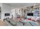 Open living room with hardwood floors, a fireplace, and built-in bookshelves adjacent to the kitchen at 23 Fairway Village Ln, Isle of Palms, SC 29451