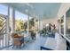 Inviting covered porch featuring wicker furniture, ceiling fans and serene views of the lush surrounding landscape at 23 Fairway Village Ln, Isle of Palms, SC 29451